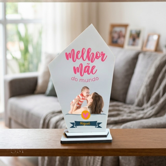 Exemplo de troféu com imagem personalizada "Melhor Mãe" em cima de uma prateleira decorada.